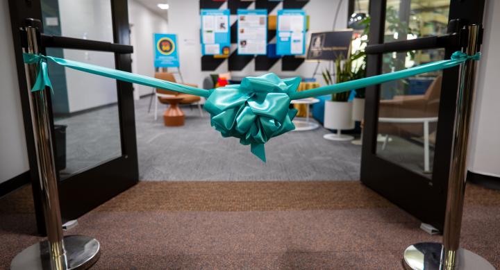 Turquoise box placed in front of two open doors leading into office suite.